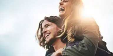 Man giving a woman a piggyback ride outdoors